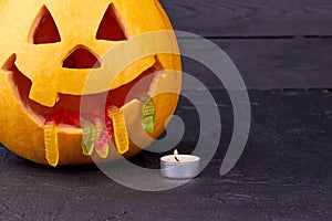 Halloween pumpkin with candle on dark background.