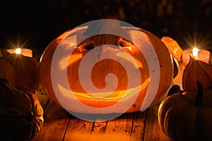 Halloween pumpkin with candle lights flame with a creepy smile carved on it