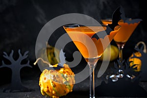 Halloween pumpkin cocktail. Food Concept, glasses with black bats and holiday decorations on dark background