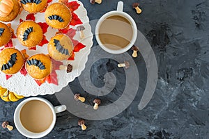 Halloween pumpkin cupcakes with 2 cups of coffee