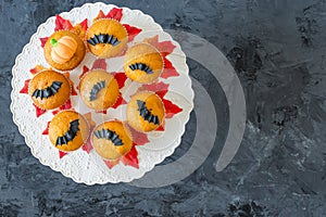 Halloween pumpkin cupcakes served on black background