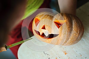 Halloween pumpkin cutting process, process of making Jack-o-lantern. Male hands with knife.