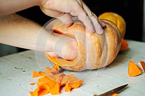 Halloween pumpkin cutting process, process of making Jack-o-lantern. Male hands with knife.