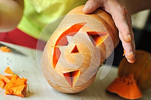 Halloween pumpkin cutting process, process of making Jack-o-lantern. Male hands with knife.