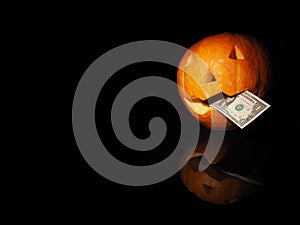 Halloween pumpkin with dollar on the black background