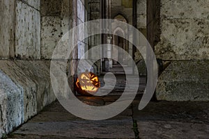 Halloween pumpkin in front of ancient stone wall of a church, Germany