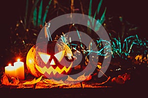 Halloween pumpkin with glowing face on a wooden background
