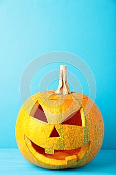 Halloween pumpkin head jack lantern on blue background. Vertical foto