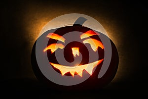 Halloween pumpkin head jack lantern with burning candles on orange background