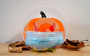 Halloween pumpkin head jack lantern with a coronavirus mask