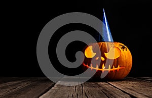 Halloween pumpkin head jack lantern with festive hubcap on wooden background