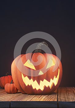 Halloween pumpkin head jack lantern on wooden planks and black background, spooky night