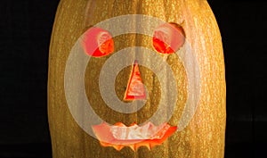 Halloween pumpkin with luminous eyes on a dark background.
