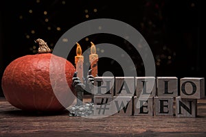 Halloween pumpkin with skeleton hands and wooden cubes