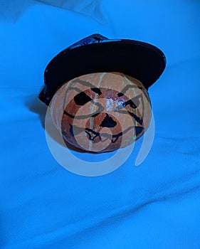 Halloween pumpkin in a snapback cap on a blue background
