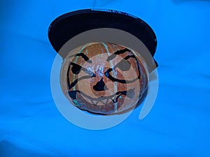 Halloween pumpkin in a snapback cap on a blue background