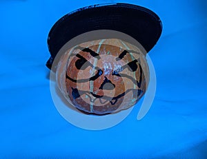 Halloween pumpkin in a snapback cap on a blue background