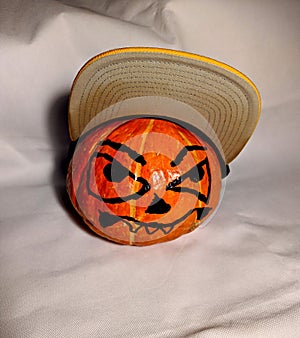 Halloween pumpkin in a snapback cap on a white background