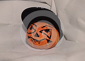 Halloween pumpkin in a snapback cap on a white background