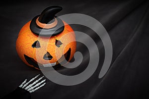 Halloween pumpkin with spooky smiling face on dark black background wiyh copy space