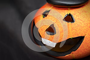 Halloween pumpkin with spooky smiling face on dark black background wiyh copy space