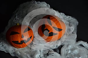 Halloween pumpkin on the web. Spiders on a black background.