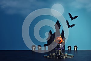 Halloween pumpkins jack-o-lantern with money coin stack growing business on dark blue background.