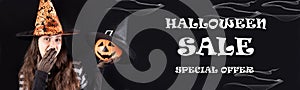 Halloween sale banner special offer. A woman in a witch costume holds a pumpkin lantern jack and covers his mouth with