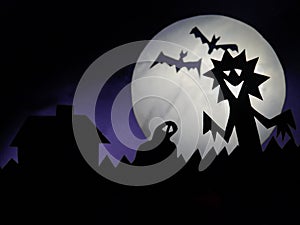 Halloween scene, Scary creatures silhouettes on a fool moon background. Funny monster, ghost and two bats in flight, Copy space,