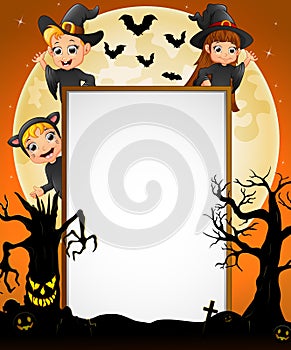 Halloween sign with little boy witch and little girl witch and cat costume and spooky tree