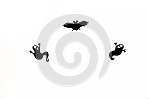 Halloween silhouettes - ghosts and a bat against white background flat lay. Halloween concept photo