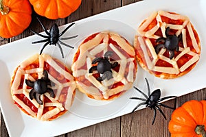 Halloween spider web mini pizzas, table scene on white plate