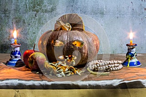 Halloween still life with pumpkins, apple, candles and rosary