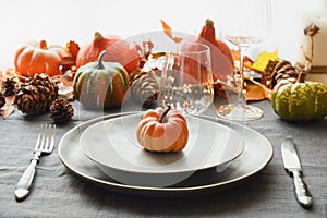 Halloween and Thanksgiving day dinner decorated fallen leaves, pumpkins, spices, grey plate.