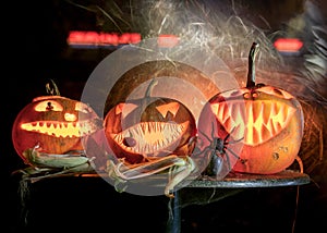 Halloween theme, carved pumpkin with a scary smile, burning candles, spiders and cobwebs, awful skulls, decoration and holiday