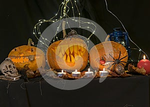 Halloween theme, carved pumpkin with a scary smile, burning candles, spiders and cobwebs, awful skulls, decoration and holiday