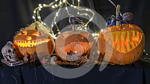 Halloween theme, carved pumpkin with a scary smile, burning candles, spiders and cobwebs, awful skulls, decoration and holiday