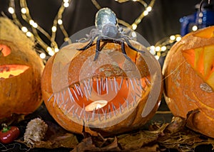 Halloween theme, carved pumpkin with a scary smile, burning candles, spiders and cobwebs, awful skulls, decoration and holiday