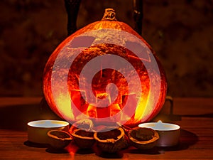 Halloween theme - pumpkin and walnut shells in the dark, lit by two candles