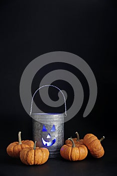 Halloween tin pail with small pumpkins on black