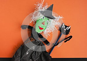 Halloween toy witch and black cat on orange