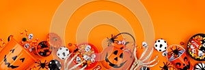 Halloween trick or treat bottom border with jack o lantern pails and candy over an orange banner background