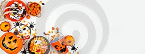 Halloween trick or treat corner border with jack o lantern pails and a selection of candy on a white banner background