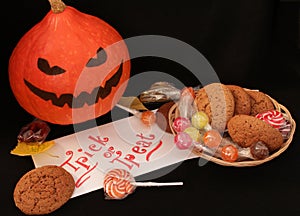 Halloween trick or treat load on a dark farm table, candy