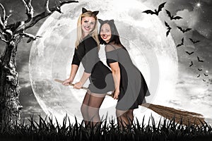 Halloween.Two witches fly on broomsticks at night in the woods.