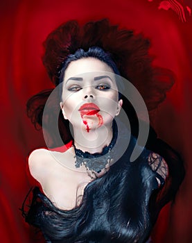 Halloween. Vampire woman lying in a bath full of blood