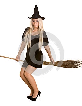 Halloween witch in black dress and hat on broom.