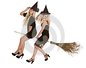 Halloween witch in black dress and hat on broom.