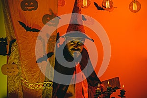Halloween Witch with a carved Pumpkin and magic lights in a dark forest. Halloween background. Jack-o-lanterns. Happy