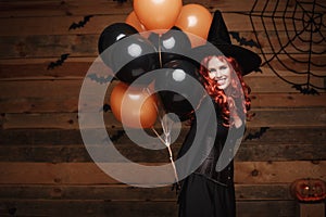 Halloween Witch Concept - Beautiful caucasian woman in witch costumes celebrating Halloween posing with posing with orange and bla